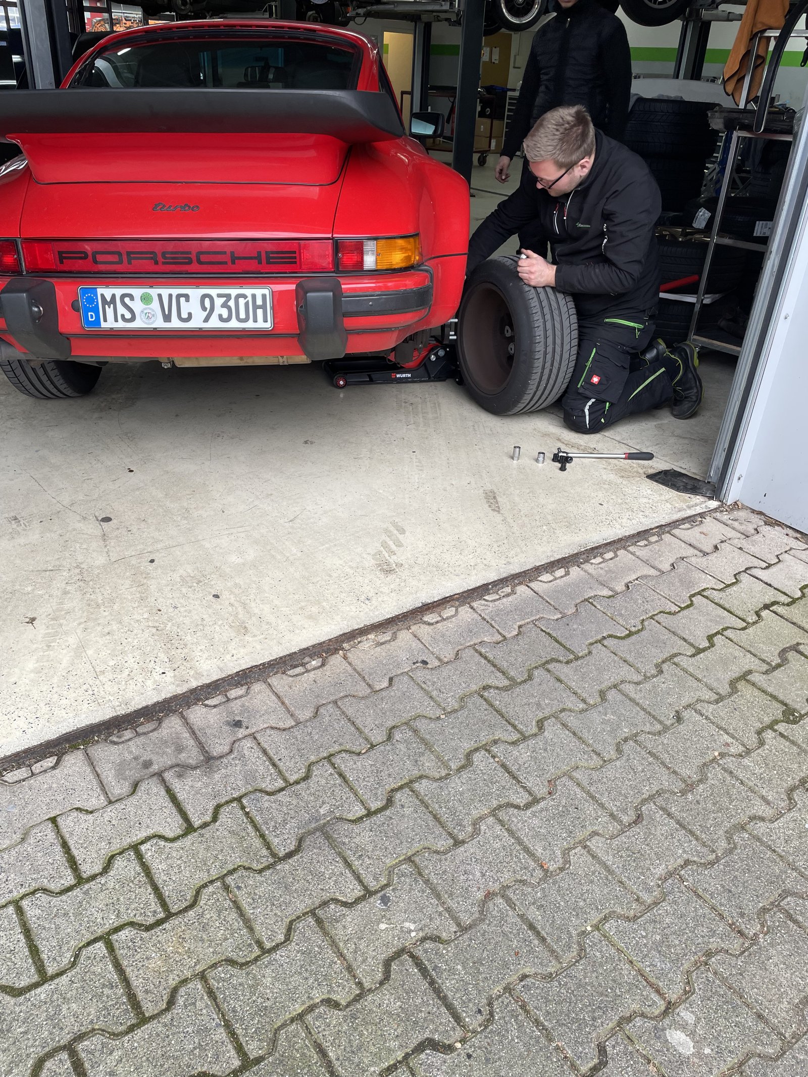 Roter 911 Turbo bei Heitgress Performance, Mechaniker am Rad